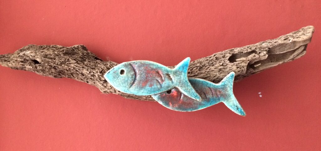 small raku fish on driftwood